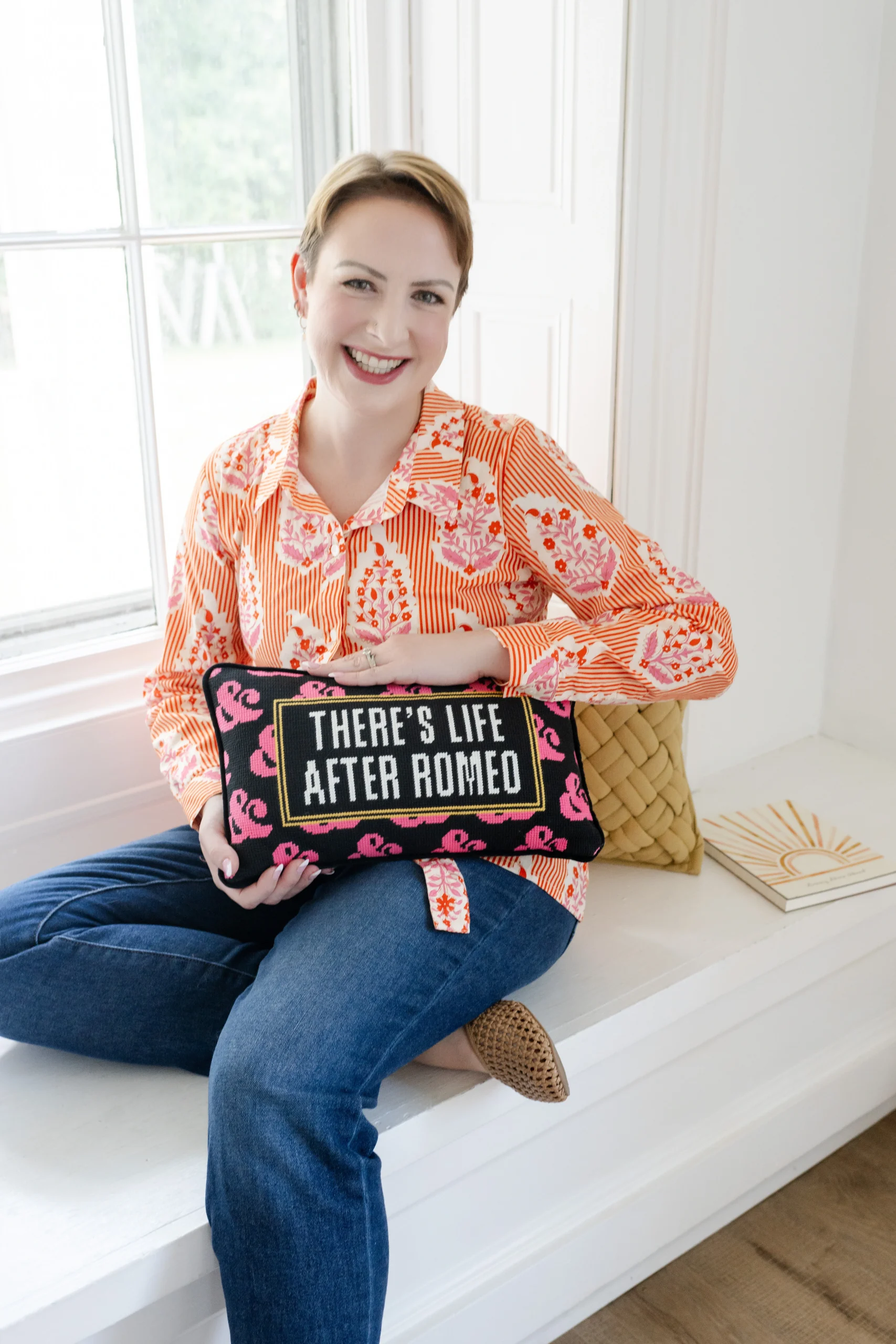 jolee-vacchi-foundations-family-law-firm-values Jolee Vacchi FFL Founding Attorney sitting with black and pink decorative pillow that reads "There's life after romeo"